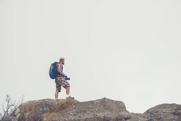 Wanderer mit Rucksack auf einem Berg stehend und die Aussicht auf die Natur genießend. - Foto, Bild