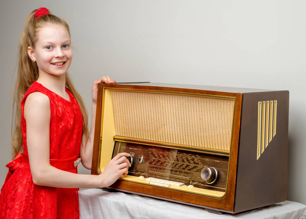 The girl is at the old radio. - Valokuva, kuva