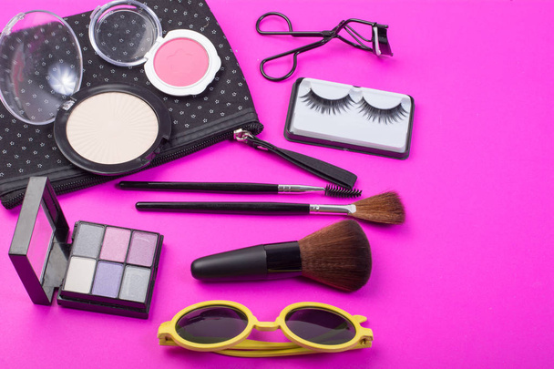 Draufsicht auf eine Schminktüte mit Kosmetikprodukten auf rosa Hintergrund. - Foto, Bild
