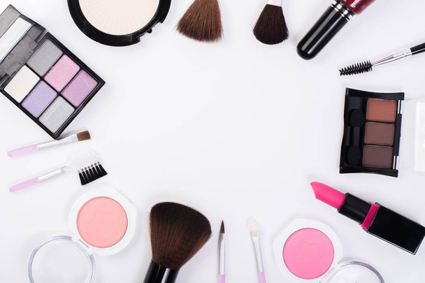 Top view of A collection of cosmetic beauty products arranged around a blank space on a white background. - Foto, Bild