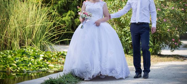 La novia y el novio están caminando en el parque - Foto, imagen