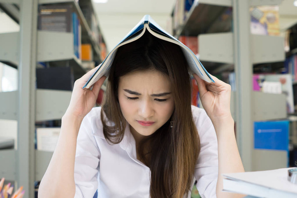 Öğrenci kitap okuma kitap kolej kütüphane içinde iken kapak kafayla portresi. Eğitim kavramı - Fotoğraf, Görsel