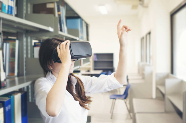 Portrait of young asian woman wearing virtual reality goggle. Education concept. - Photo, Image