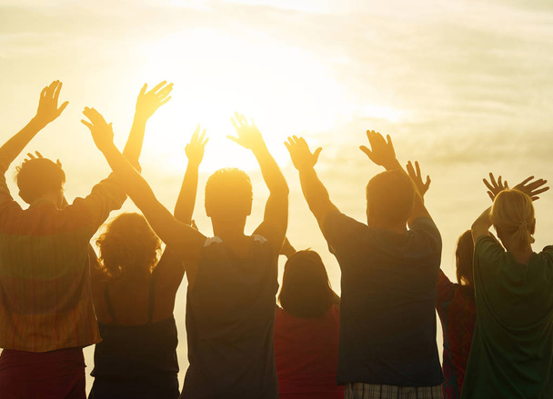 Hands up against sunset background. - Photo, Image