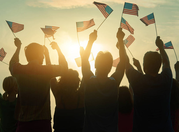 Silhouetten van mensen die de vlag van Verenigde Staten. - Foto, afbeelding
