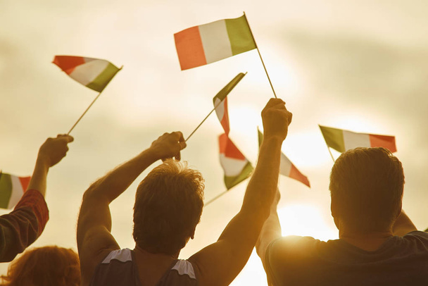 Молодые люди машут итальянскими флагами, вид сзади
. - Фото, изображение