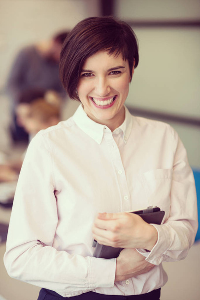 young hispanic businesswoman portrait with  tablet computer at modern startup business office interior, people group on team meeting blured in background - Valokuva, kuva