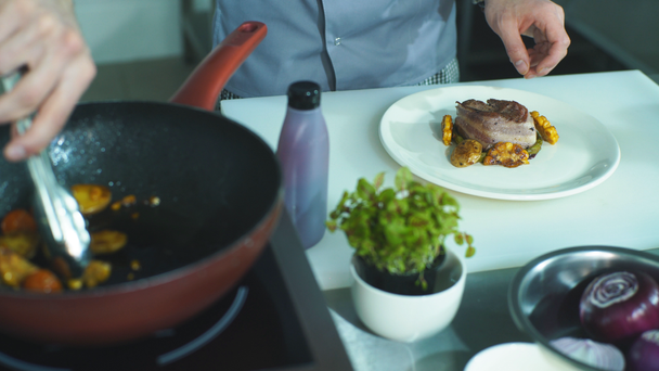 szakács zöldség helyez egy tál hús - Felvétel, videó