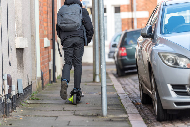 Çocuk İngiltere'de İngiliz okul sürüş elektrikli scooter üzerinde - Fotoğraf, Görsel
