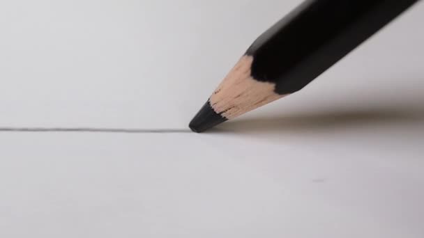 Streep zwart op wit tekenpapier met zwarte kleur potlood. artistiek concept. - Video