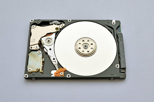 disque dur démonté pour ordinateur portable sur fond blanc. surface semblable à un miroir attire l'œil
 - Photo, image
