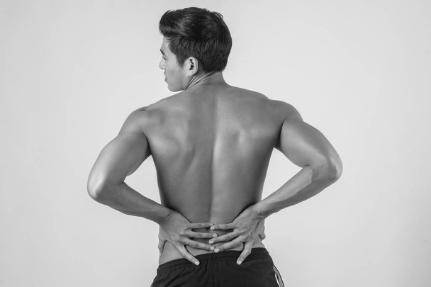 Közelkép a férfi dörzsölés fájdalmas hátán elszigetelt fehér background. - Fotó, kép