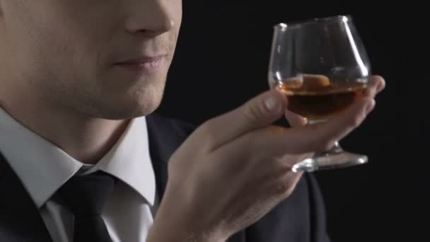 Politician enjoying taste of cognac and smiling, celebrating successful deal - Záběry, video