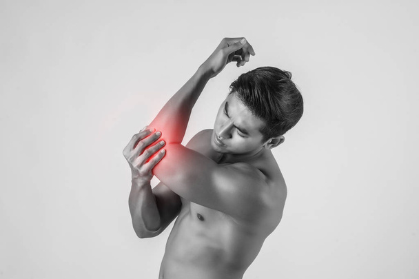 Porträt eines Muskelprotzes mit Ellbogenschmerzen isoliert auf weißem Hintergrund - Foto, Bild