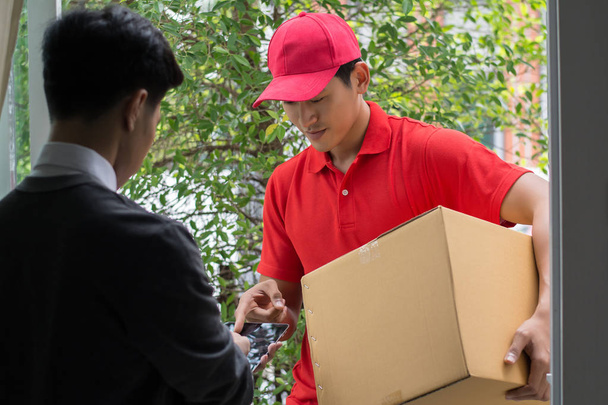 Young man Delivering Package to customer at home. Delivery - Фото, изображение