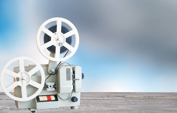 Vintage film projector on a table on a background of a blurry sky - Photo, Image