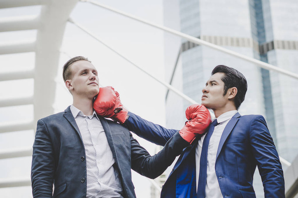 Homme d'affaires avec des gants de boxe rouge prêt à combattre son collègue
. - Photo, image