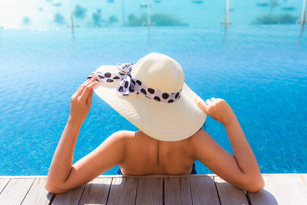 Portait de mujer asiática relajándose en piscina con baño de sol
 - Foto, Imagen