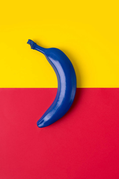 Blue banana on the bright background of red and yellow colors. Top view image - Foto, Imagen