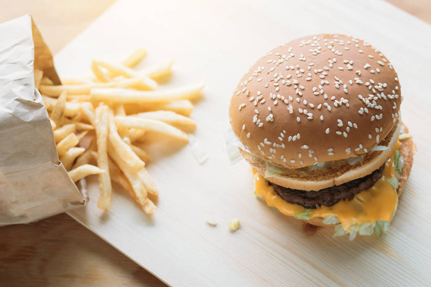 Hamburger sul pavimento in legno e patatine fritte
 - Foto, immagini