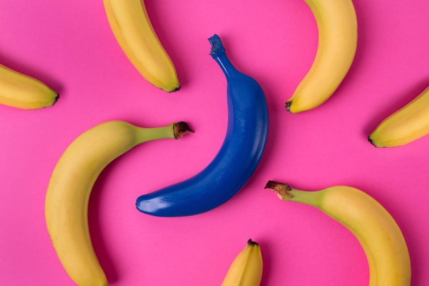 Top view of fresh yellow and blue bananas isolated on pink background. - Фото, изображение