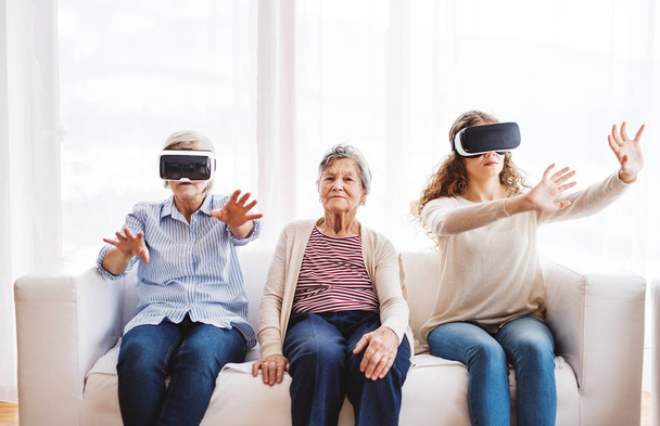 A teenage girl, mother and grandmother with VR goggles at home. - Valokuva, kuva