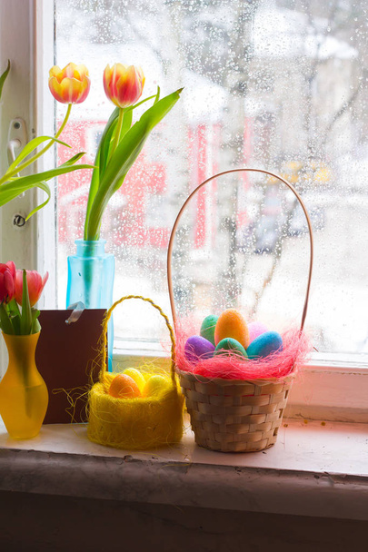 Bouquets de tulipas em um vaso e ovos tingidos em uma cesta Tulipa e ovos tingidos
 - Foto, Imagem