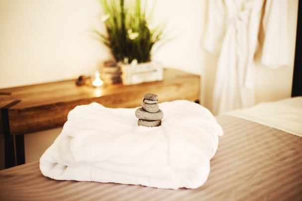 Valkoinen kylpytakki sängyllä kylpylässä
 - Valokuva, kuva