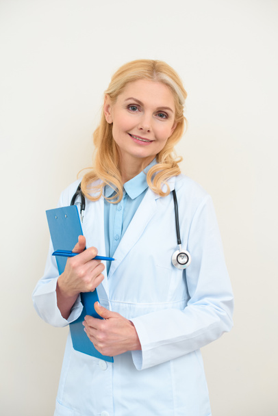 happy female doctor with clipboard on white - Zdjęcie, obraz