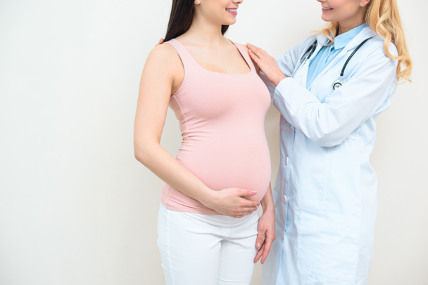 colpo ritagliato di ginecologo ostetrico che sostiene la donna incinta
 - Foto, immagini