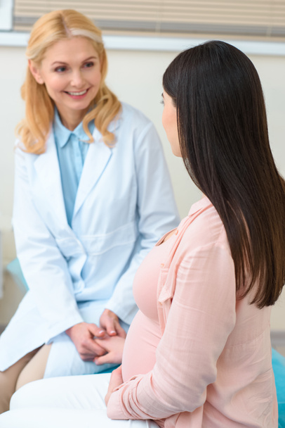 kypsä synnytyslääkäri gynekologi tilalla käsi raskaana olevan naisen
 - Valokuva, kuva