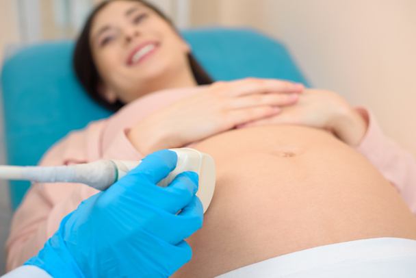 close-up shot of obstetrician gynecologist making ultrasound examination for pregnant woman - Photo, Image
