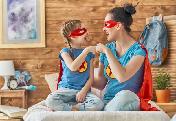 女の子とスーパー ヒーローの衣装のお母さん - 写真・画像
