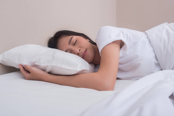 Jovem mulher dormindo em sua cama
 - Foto, Imagem