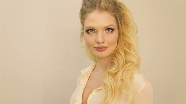 Dolgun dudaklar ve uzun sarı saçları olan bir kız portresi - Video, Çekim