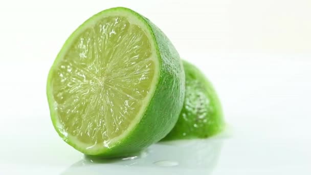 A lime cut in half and arranged on a white background - Footage, Video