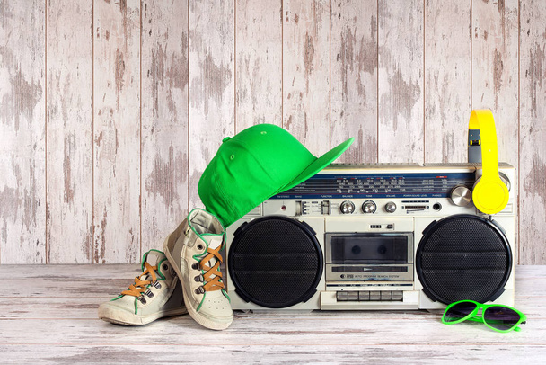 The concept of the music Hip hop style.Vintage audio player with headphones,fashionable cap, sneakers and sunglasses. - Valokuva, kuva