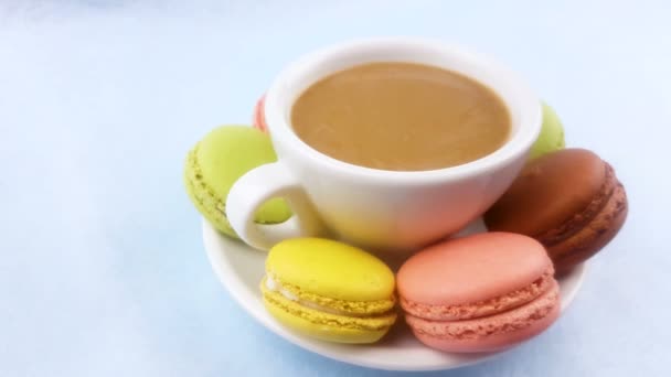 Macarrones o macarones en superficie de color rosa pastel con café en taza blanca
. - Imágenes, Vídeo