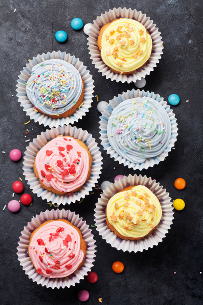 Pastelitos dulces con decoración colorida y dulces. Vista superior
 - Foto, imagen
