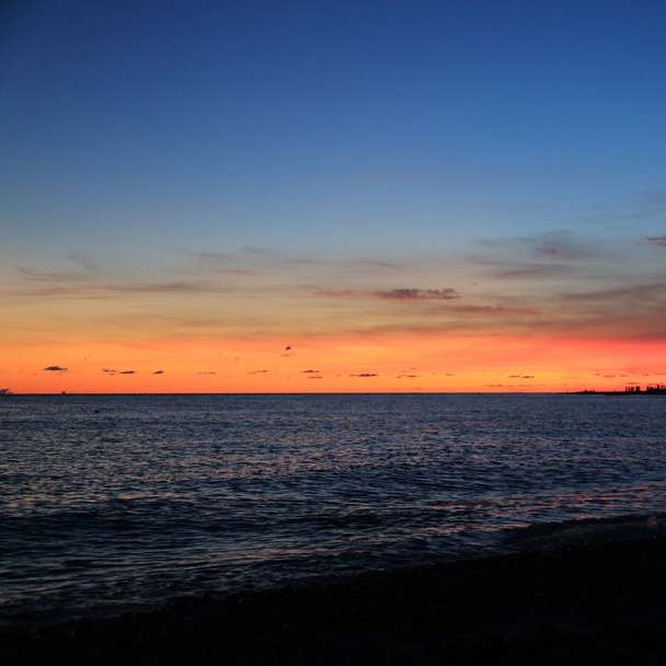 Καλοκαιρινό ηλιοβασίλεμα πάνω από την παραλία της Μαύρης Θάλασσας στο Σότσι, Ρωσική Ομοσπονδία. Επιλεγμένη εστίαση. - Φωτογραφία, εικόνα