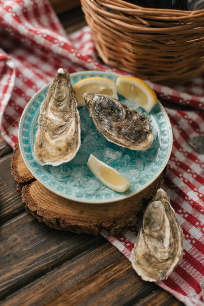 Sommige verse rauwe oesters met citroen segmenten in plaat - Foto, afbeelding