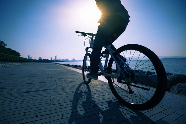 silhouette cyclist riding bike in the sunrise coast road - Foto, immagini