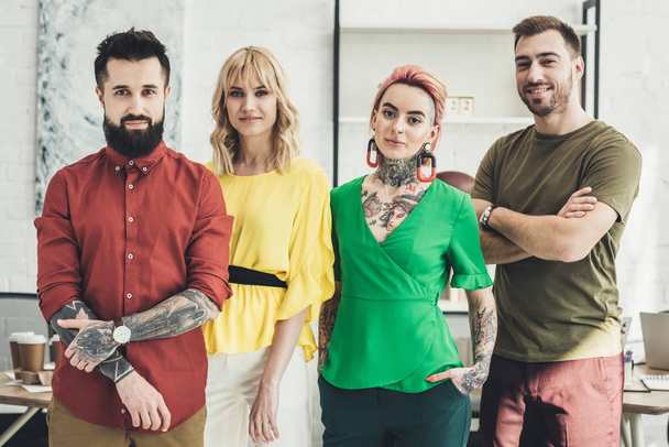 portrait of group of young stylish creative workers looking at camera in office - Foto, Bild