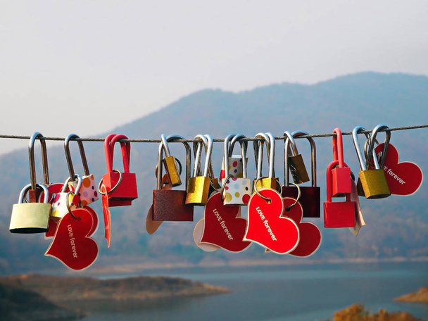 山と湖を背景にカラフルな愛の南京錠 - 写真・画像