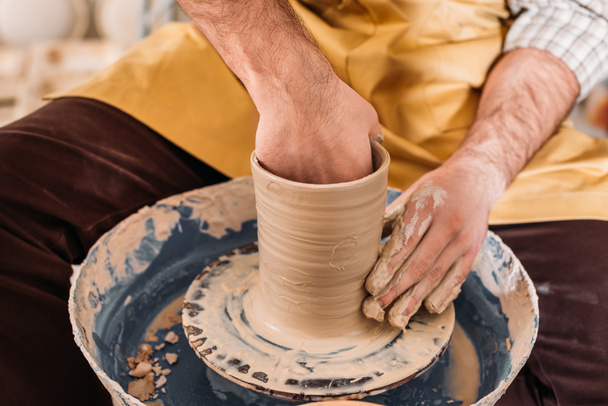 cropped view of potter making ceramic pot on pottery wheel  - Photo, Image
