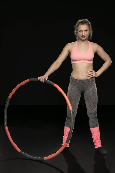 athletic woman holding hula hoop in her hands, isolated on the b - Fotó, kép