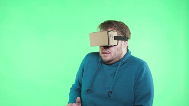 Man in vr glasses enjoy on the green background - Кадры, видео