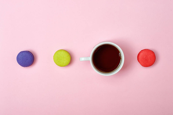 Colorful sweet macaroons and a cup of tea. Delicious breakfast. Top view. - Fotoğraf, Görsel
