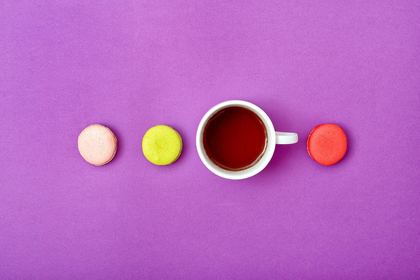 Colorful sweet macaroons and a cup of tea. Delicious breakfast. Top view. - Foto, Imagem