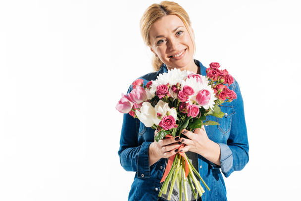 Pretty smiling woman holding bouquet of flowers isolated on white - Fotoğraf, Görsel